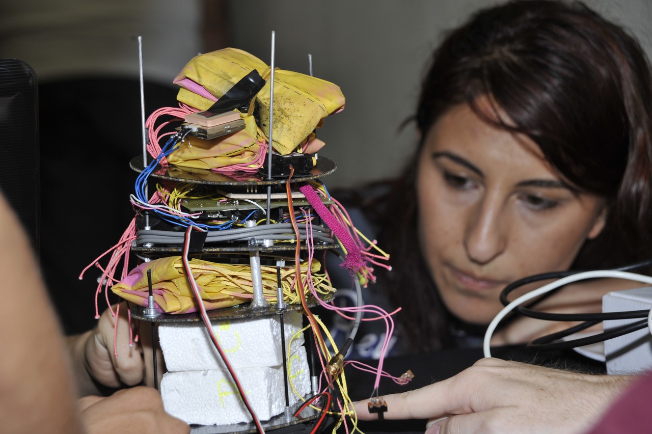 Image description: A student participating in the CanSat competition goes through a pre-flight safety check of her satellite.
The CanSat competition, sponsored by the Navy Research Laboratory and NASA, challenged teams of college students to develop a satellite in a can with a special deployable part that would land safely and protect a raw egg inside.
The satellites were launched about 2001 feet in the air by rockets.
Twenty-six team entered the competition, held in Texas, and earned points based on design, pre-flight inspections and post-flight reviews.
Learn more about the CanSat competition.
Photo from the Navy Research Laboratory.