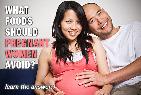 Expecting married couple, sitting on couch and smiling. Text: What foods should pregnant women avoid? Learn the answer.