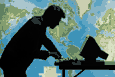 Picture of person at computer in front of world map