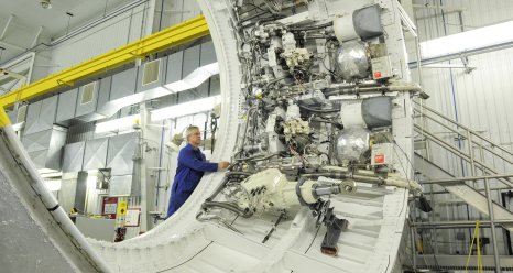 A technician checks the avionics test article for solid rocket boosters for a flight control test for SLS.
