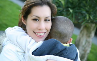 Una mujer sonríe mientras abraza a su hijo