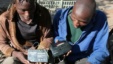 Two men in Bulawayo, Zimbabwe listen to a battery-operated radio for the results of the country's 2008 elections in this file photo.