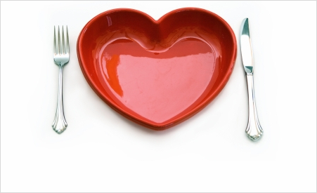 red, heart-shaped dinner plate with fork and knife