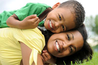 Photo: Mother and son lying on grass, laughing