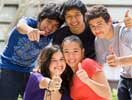 Photograph of diverse teens smiling and giving the thumbs up.