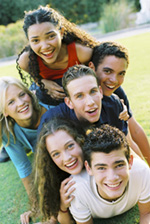 Smiling teens crowd together for a group photograph.