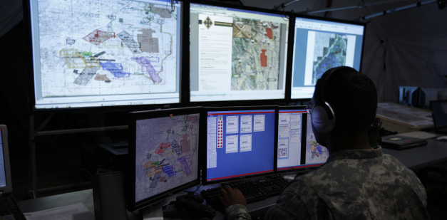 Intelligence soldier looking at multiple computer screens