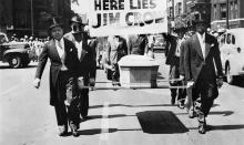 NAACP parade with marchers carrying a coffin for Jim Crow.