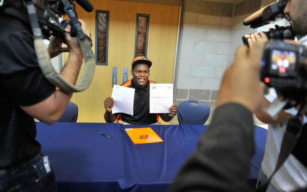 Madison High School football player Vincent Taylor shows off his signed scholarship to Oklahoma State University during a National Signing Day event at the school Wednesday. Photo: Robin Jerstad