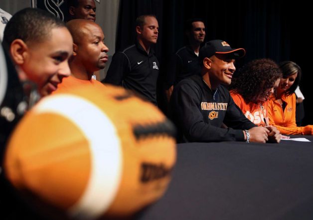 Steele High School football player Jordan Sterns, wearing hat and surrounded by his family and coaches, smiles Wednesday Feb. 6, 2013 after signing his letter of intent on National Signing Day to play football at Oklahoma State University. Photo: William Luther, San Antonio Express-News / © 2013 San Antonio Express-News