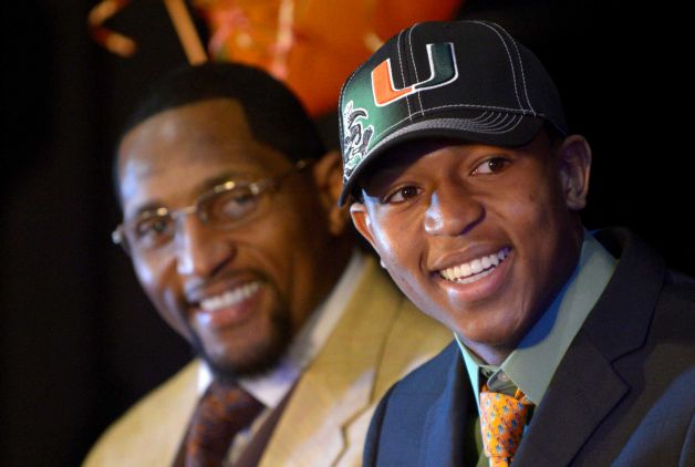 Ray Lewis III, right, smiles as he is introduced during a national signing day ceremony in the Lake Mary Prep auditorium as his father, former Baltimore Ravens linebacker Ray Lewis Jr., watches in Lake Mary, Fla., Wednesday, Feb. 6, 2013. Lewis signed a letter of intent to play football at the University of Miami, where his father also played college football. (AP Photo/Phelan M. Ebenhack) Photo: Phelan M. Ebenhack, Associated Press / FR121174 AP