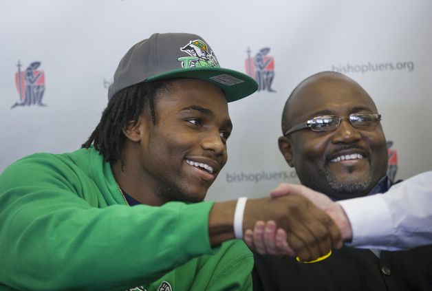 Jaylon Smith, a linebacker from Bishop Luers, greets someone while sitting next to his father, Roger Smith, Wednesday, Feb. 6, 2013, in Fort Wayne, Ind. Smith signed a letter of intent with Notre Dame. (AP Photo/The Journal-Gazette, Swikar Patel) NEWS-SENTINEL OUT  MAGS OUT  NO SALES Photo: Swikar Patel, Associated Press / The Journal-Gazette
