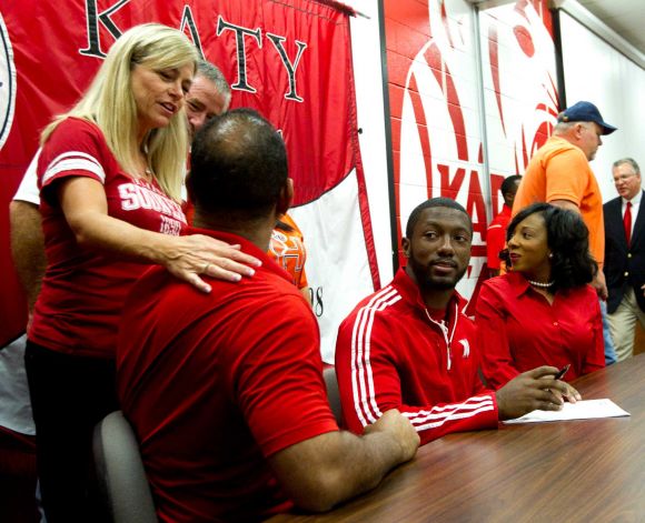 Cindi Dimon, left, congratulates Barry Taylor, father of Nebraska signee Adam Taylor, right, during a National Letter of Intent signing ceremony at Katy High School Wednesday, Feb. 6, 2013, in Katy. Dimon's son, Matt, signed to play football at Oklahoma. Photo: Brett Coomer, Houston Chronicle / © 2013 Houston Chronicle