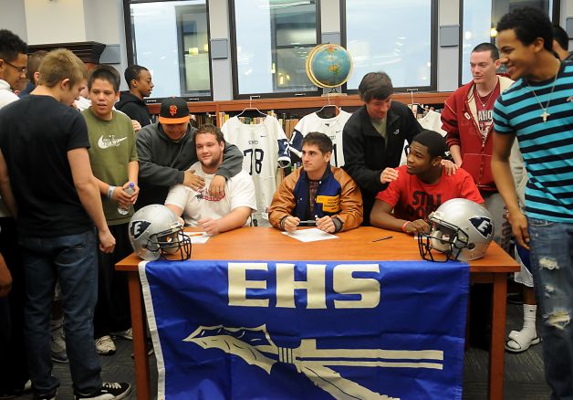 Enid High School Plainsmen, seated from elft, Logan Miller, Seth Handley and Lance Smith, receive congratulations from their teammates during national signing day at the EHS Library, Wednesday, Feb. 6, 2013, in Enid, Okla. (AP Photo/Enid News and Eagle, Bonnie Vculek) Photo: BONNIE VCULEK, Associated Press / Enid News And Eagle