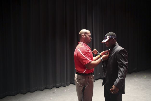 Bayside High School running back Taquan Mizzell gets a little help from coach Jonathan White in adjusting his tie, before signing a letter of intent with Virginia on Wednesday, Feb. 6, 2013, in Virginia Beach, Va. (AP Photo/The Virginian-Pilot, Ross Taylor) MAGS OUT Photo: Ross Taylor, Associated Press / The Virginian-Pilot