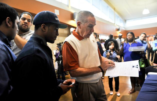 Madison High School football coach Jim Streety (right) looks over the scholarship to Yale that was signed by player Galen McCallister (left) during National Signing Day activities at the school Wednesday. Photo: Robin Jerstad