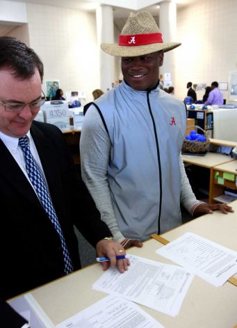 Reuben Foster signs a letter of intent to attend the University of Alabama and play college football as his coach Tim Carter looks on during National Signing Day on Wednesday, Feb. 6, 2013, in Auburn, Ala. (AP Photo/Butch Dill) Photo: Butch Dill, Associated Press / FR111446 AP