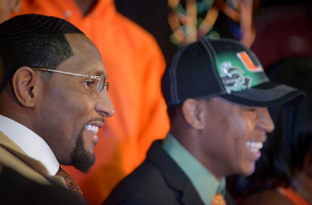 former Baltimore Ravens linebacker Ray Lewis Jr., left, smiles as his son Ray Lewis III signs his letter-of-intent form during a national signing day ceremony in the Lake Mary Prep auditorium in Lake Mary, Fla., Wednesday, Feb. 6, 2013. Lewis signed to play football at the University of Miami, where his father also played college football. (AP Photo/Phelan M. Ebenhack) Photo: Phelan M. Ebenhack, Associated Press / FR121174 AP