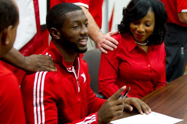 Nebraska signee Adam Taylor, left, and his mother, Fedora Taylor, right, get pats on the back during a National Letter of Intent signing ceremony at Katy High School Wednesday, Feb. 6, 2013, in Katy. Photo: Brett Coomer, Houston Chronicle / © 2013 Houston Chronicle