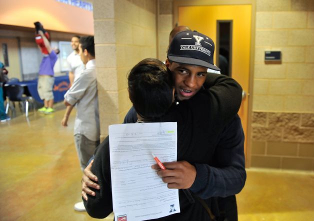 Madison High School football player Galen McAllister gets a hug from Virgina Hunter during the National Signing Day event at the school Wednesday. McAllister has signed to play at Yale next year. Photo: Robin Jerstad