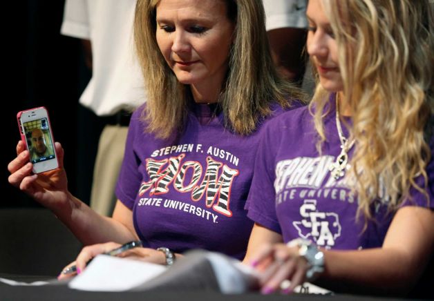 Joined by her father, Maj. Eric Glasz via Facetime on an iPhone from Bagram, Afghanistan, and her mother, Teri Glasz, Steele High School's Taylor Glasz signs a letter of intent on National Signing Day Wednesday Feb. 6, 2013 to run track at Stephen F. Austin University. Photo: William Luther, San Antonio Express-News / © 2013 San Antonio Express-News