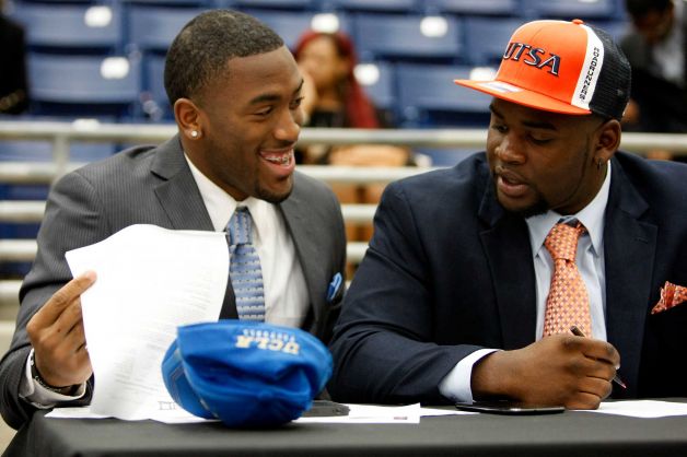 Fort Bend Marshall linebacker Deon Hollins Jr., left, who committed to play football at UCLA, shares a laugh with teammate Anthony Lee who committed to the University of Texas San Antonio during a signing day ceremony at the Buddy Hopson Field House Tuesday, Feb. 5, 2013, in Missouri City. Photo: Johnny Hanson, Houston Chronicle / © 2013  Houston Chronicle