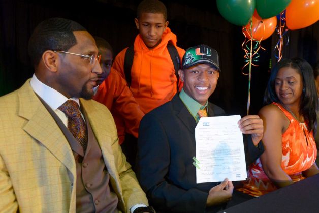 Ray Lewis III, second from right, shows his national letter-of-intent form as his father, former Baltimore Ravens linebacker Ray Lewis Jr., left, his mother Tatyana McCall, and brothers Rahsaan, 12, second from left, and Rayshad, 14, center, watch during a national signing day ceremony in the Lake Mary Prep auditorium in Lake Mary, Fla., Wednesday, Feb. 6, 2013. Lewis signed a letter of intent to play football at the University of Miami, where his father also played college football. (AP Photo/Phelan M. Ebenhack) Photo: Phelan M. Ebenhack, Associated Press / FR121174 AP