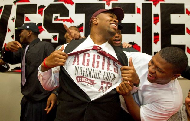 Texas A&M signee Hardreck Walker and his brother Chris Hall, right, laugh as Hardreck shows off an Aggies t-shirt during a national signing ceremony at Westfield High School Wednesday, Feb. 6, 2013, in Houston.(AP Photo/Houston Chronicle,  Brett Coomer) MANDATORY CREDIT \ Photo: Brett Coomer, Associated Press / Houston Chronicle