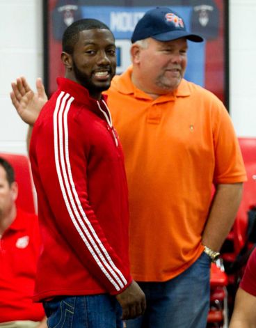 Adam Taylor, left, gets a pat on the back from Doug Sowell during a National Letter of Intent signing ceremony at Katy High School Wednesday, Feb. 6, 2013, in Katy. Taylor signed a letter of intent to play football at Nebraska. Photo: Brett Coomer, Houston Chronicle / © 2013 Houston Chronicle