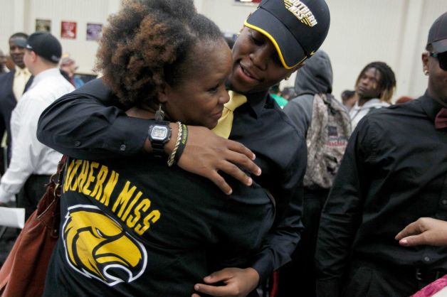 Hightower High School's Kelsey Douglas gets a hug from his mother Ingrid Douglas as he made his commitment to play football at Southern Miss during a signing day ceremony at the Buddy Hopson Field House Tuesday, Feb. 5, 2013, in Missouri City. Photo: Johnny Hanson, Houston Chronicle / © 2013  Houston Chronicle