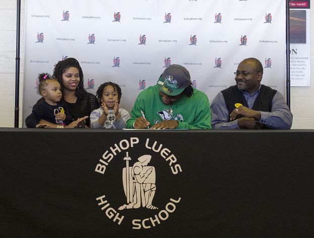 Jaylon Smith, second from right, signs a letter of intent with Notre Dame, while seated with his father, Roger Smith, right; mother, Sophia Woodson, second from left; cousin Alaja Williams, 2, left; and brother Leslie Woodson, 3, at Bishop Luers High School on Wednesday, Feb. 6, 2013, in Fort Wayne, Ind. (AP Photo/The Journal-Gazette, Swikar Patel) NEWS-SENTINEL OUT  MAGS OUT  NO SALES Photo: Swikar Patel, Associated Press / The Journal-Gazette