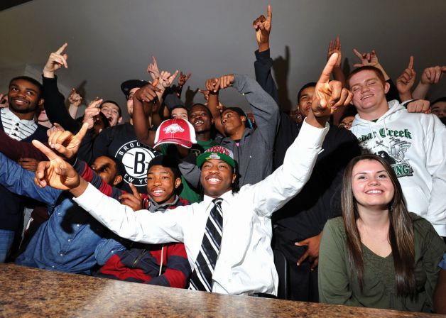 Cedar Creek High School's Damon Mitchell, center, celebrates with teammates after signing a letter of intent to play NCAA college football for Arkansas State, Wednesday, Feb. 6, 2013, in Egg Harbor City, N.J. (AP Photo/The Press of Atlantic City, Michael Ein) MANDATORY CREDIT Photo: Michael Ein, Associated Press / The Press of Atlantic City