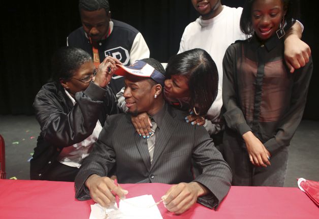 Bayside High School running back Taquan Mizzell sits in front of family members Wednesday, Feb. 6, 2013, at the high school in Virginia Beach, Va., where he signed a letter of intent with Virginia. From left are Dorothy Hambric, Courtney Littlejohn, Dyshell Gardner, Jerome Williams and Dekeara Mizzell. (AP Photo/The Virginian-Pilot, Ross Taylor) MAGS OUT Photo: Ross Taylor, Associated Press / The Virginian-Pilot