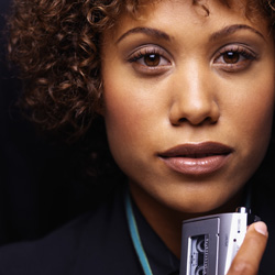 Photograph of a young woman holding a tape recorder.