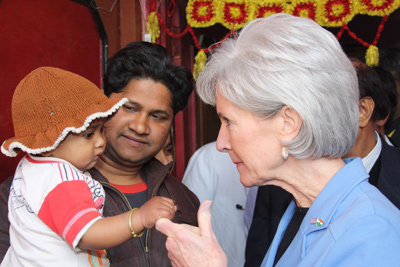 Secretary Sebelius interacting with a sick child. Rural village about 50km from Delhi, India.