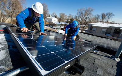 Photo of two men installing a solar panel.