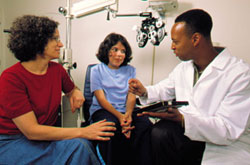 A doctor talks to his young patient and her mother.