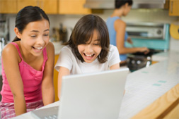 Dos niñas interactuando con computadora
