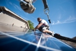 Brian Webster installs rooftop solar panels on a home in Englewood, Colorado. The Energy Department is working to streamline rooftop solar installations so that its faster, easier and cheaper for Americans to go solar. | Photo courtesy of Dennis Schroeder, NREL. 