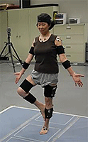 A woman practices yoga while wearing electronic position monitors.