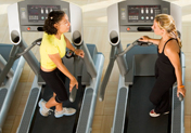 women talking on treadmills