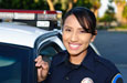 Photograph of a policewoman standing next to her car.