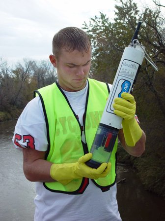 An Earth Team volunteer inspecting water sample probe
