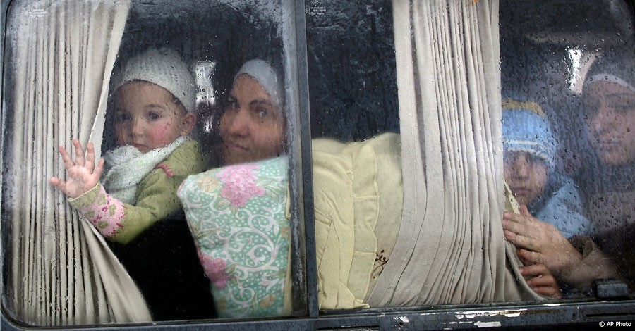 Syrian refugees look out of a vehicle's window just after crossing the border from Syria to Turkey, in Cilvegozu, Turkey, December 20, 2012. [AP Photo]