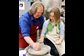 Teacher showing student how to work at a pottery wheel