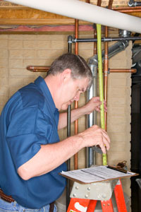 Photograph of of a man looking at a checklist as he inspects a building.