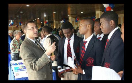 Scott Johnson of North Hennepin Community College and other recruiters advise students at a College and Career Fair in Abuja, Nigeria