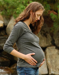 Photograph of a pregnant teen outdoors.