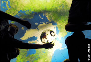一群孩子在一个大气球内抛掷地球仪。（AP Images/渥太华先驱报/Elliot J. Sutherland）