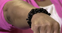 A woman's arm with a bracelet made from pices of black coral on her wrist